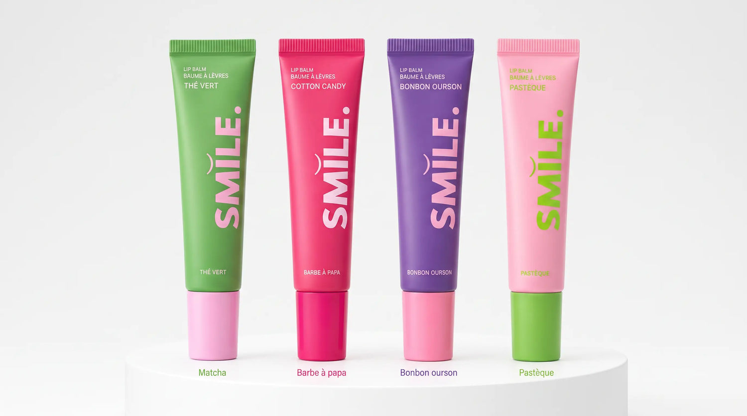 Quatre baumes à lèvres Smile Addict alignés : Thé Vert, Barbe à Papa, Bonbon Ourson et Pastèque