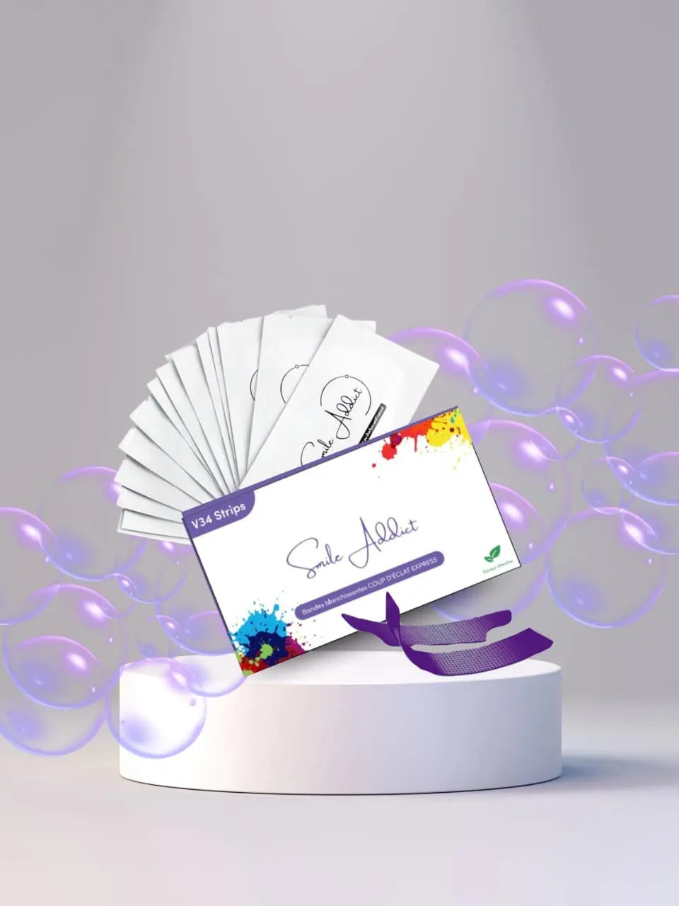 A box labeled Bandes Éclat Express V34 – Blanchiment Dentaire Instantané Sans Peroxyde by Smile Addict sits on a white pedestal with a purple ribbon, surrounded by fanned-out packets and floating purple bubbles on a light background.