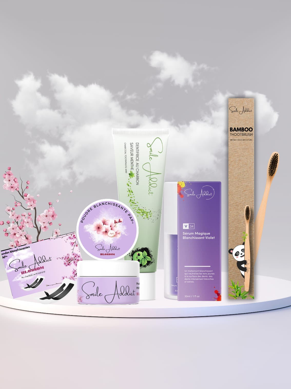 The PACK COMPLET BLANCHEUR INTENSE 🌿🚀 – Routine 5 Produits Smile Addict, featuring skincare items and bamboo toothbrushes for blanchiment dentaire and dents sensibles, is displayed with a panda figurine and cherry blossoms for decoration.