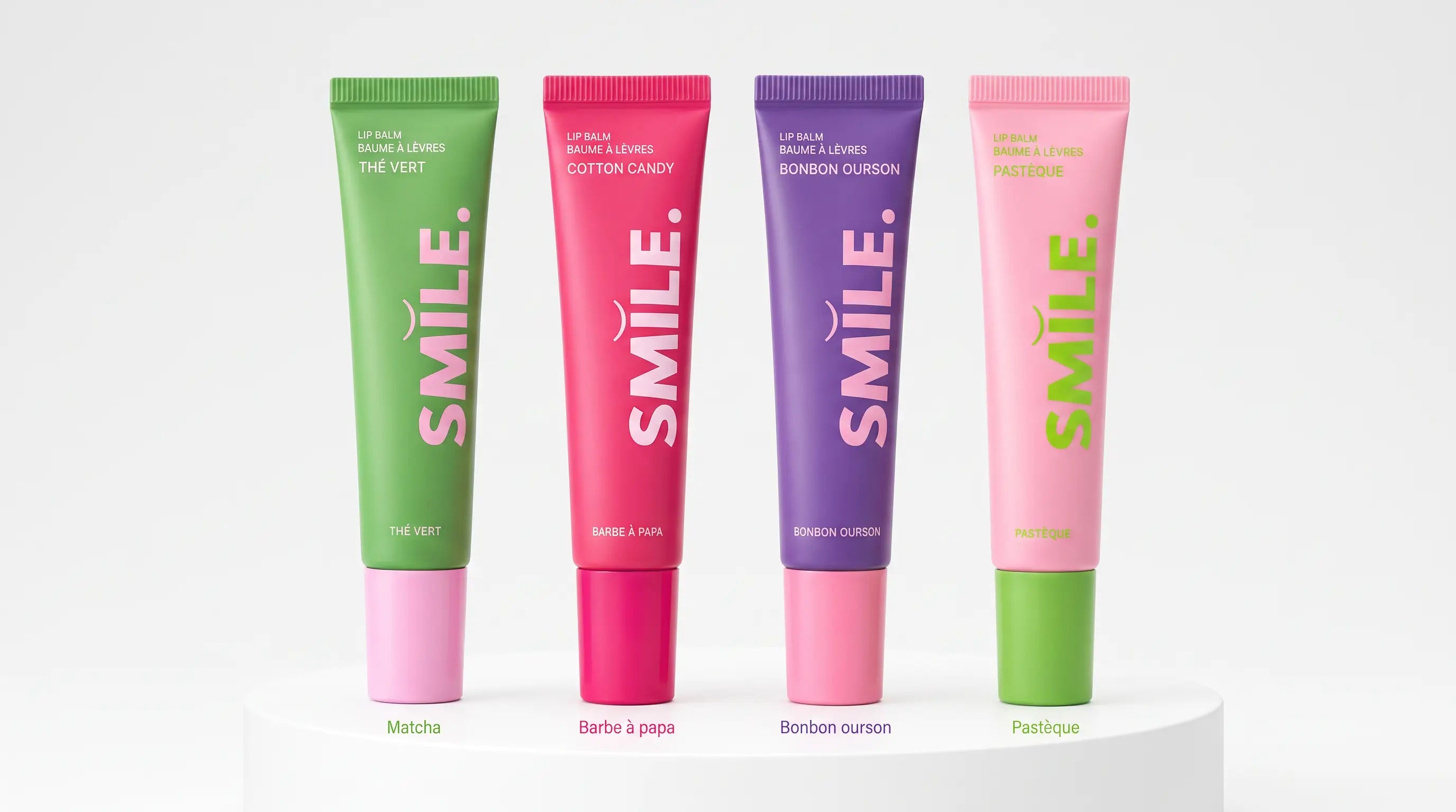 Quatre baumes à lèvres Smile Addict alignés : Thé Vert, Barbe à Papa, Bonbon Ourson et Pastèque