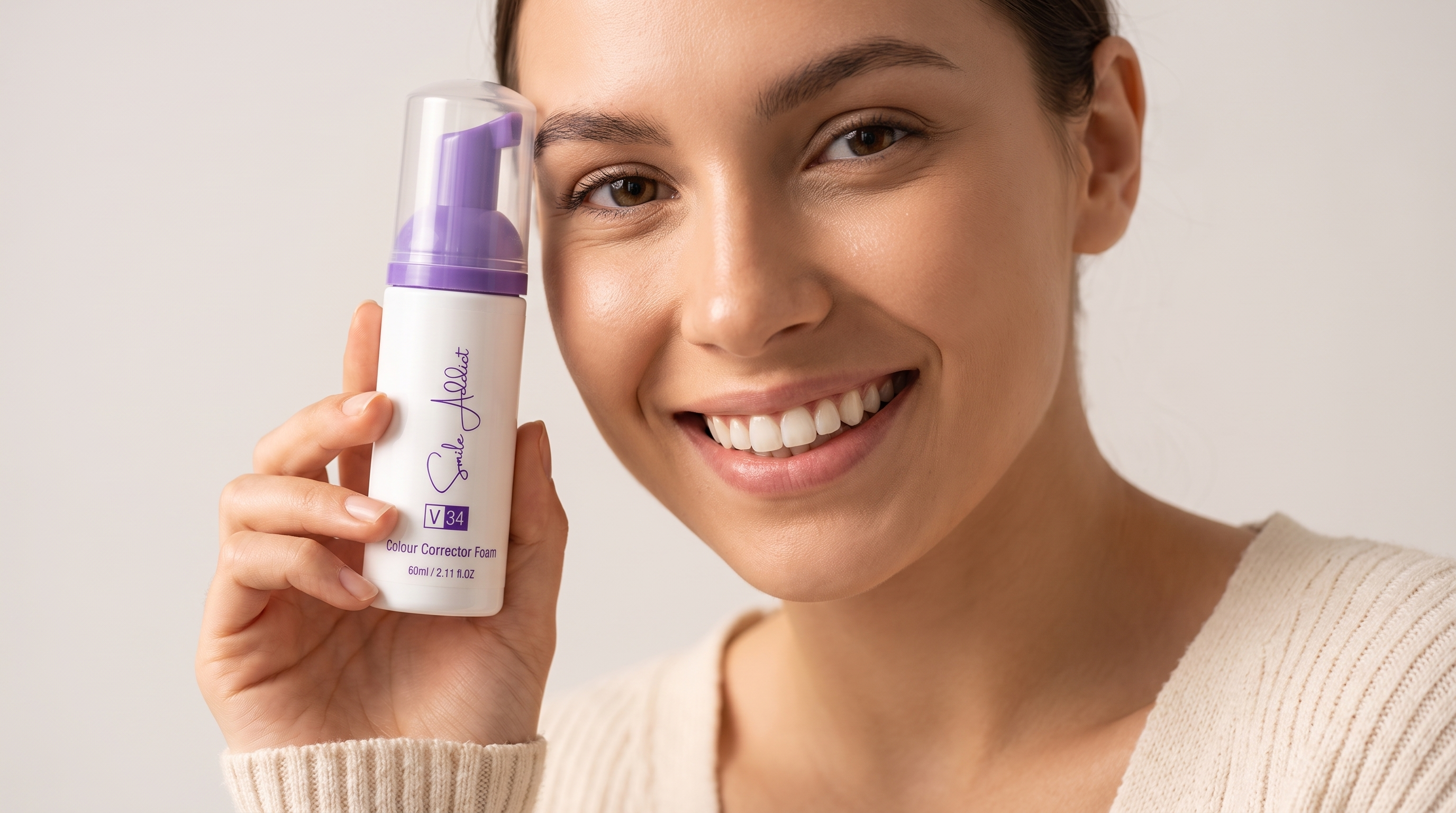 Mousse V34 Smile Addict tenue par une femme souriante pour respecter les hauts standards de blanchiment dentaire